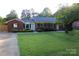 Charming brick home featuring a well-maintained lawn and mature trees, creating a welcoming curb appeal at 1421 Thompson Ave, Charlotte, NC 28216