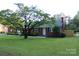 Traditional brick home with mature shade tree in the front yard at 1421 Thompson Ave, Charlotte, NC 28216