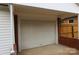 Attached garage with brick accents, concrete floors, and white door at 1421 Thompson Ave, Charlotte, NC 28216