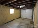 The inside of a spacious garage, showing the concrete floor, window, and door at 1421 Thompson Ave, Charlotte, NC 28216