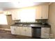 Updated kitchen features stainless steel appliances, gray countertops, and sleek white cabinets at 1421 Thompson Ave, Charlotte, NC 28216