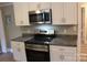 Close-up of new oven, microwave and granite countertop at 1421 Thompson Ave, Charlotte, NC 28216