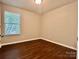 A neutral bedroom features a window and dark hardwood floors at 14211 Harlequin Dr, Charlotte, NC 28273