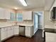 Well-lit kitchen with white cabinets, stainless steel dishwasher, and a view into the connecting dining area at 14211 Harlequin Dr, Charlotte, NC 28273