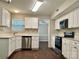 Modern kitchen with sleek white cabinets, stainless steel appliances, and dark wood-look flooring at 14211 Harlequin Dr, Charlotte, NC 28273