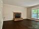 Cozy living room featuring a brick fireplace and large window, creating a warm and inviting space at 14211 Harlequin Dr, Charlotte, NC 28273