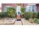 Inviting front entrance with landscaped garden beds and a charming glass front door with black railing at 14615 Bridle Trace Ln, Pineville, NC 28134
