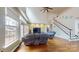 Bright living room with large windows, hardwood flooring, and a staircase at 14615 Bridle Trace Ln, Pineville, NC 28134