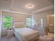 Calm main bedroom featuring tray ceilings, neutral colors, and en suite bathroom at 14806 Tamarack Dr, Charlotte, NC 28278