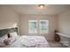 This bright bedroom features two windows, neutral walls, and a comfortable bed at 14806 Tamarack Dr, Charlotte, NC 28278