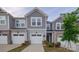 Charming townhome featuring a gray exterior, attached garage, and manicured landscaping at 14806 Tamarack Dr, Charlotte, NC 28278