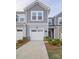 Beautiful townhome featuring a gray exterior, attached garage, and meticulously maintained landscaping at 14806 Tamarack Dr, Charlotte, NC 28278