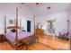 Spacious bedroom with hardwood floors, four-poster bed, and adjoining bathroom at 150 8Th Ave, New London, NC 28127