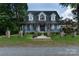 Charming two-story home featuring a well-manicured lawn and unique stone archway leading to the front door at 150 8Th Ave, New London, NC 28127