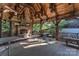 Inviting outdoor living space with wood beams, stone fireplace, and ample seating for enjoying the outdoors at 150 8Th Ave, New London, NC 28127