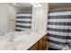 Bright bathroom with double sink vanity and a shower featuring a stylish striped curtain at 1518 Glenbar Ct, Clover, SC 29710