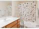 Well-lit bathroom with oak vanity and stylish shower curtain at 1518 Glenbar Ct, Clover, SC 29710