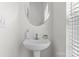 All-white half bathroom with a round mirror and pedestal sink at 1530 S Church St # K, Charlotte, NC 28203