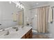 Bathroom with double sink vanity, large mirror, shower with curtain, and tiled floors at 1530 S Church St # K, Charlotte, NC 28203