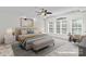 Staged bedroom features a neutral color palette, a ceiling fan, and large windows at 1530 S Church St # K, Charlotte, NC 28203