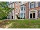 Brick townhome exterior featuring a bay window, shutters, and well-maintained lawn at 1530 S Church St # K, Charlotte, NC 28203