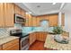 Spacious kitchen featuring wooden cabinets, stainless steel appliances, and unique backsplash at 1530 S Church St # K, Charlotte, NC 28203
