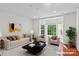 Staged living room showcasing a large bay window, hardwood floors, and contemporary furnishings at 1530 S Church St # K, Charlotte, NC 28203