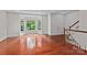 Bright living room featuring hardwood floors, a bay window, and staircase access at 1530 S Church St # K, Charlotte, NC 28203