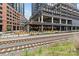 Outdoor dining area of a restaurant featuring overhead string lights, and train tracks in front at 1530 S Church St # K, Charlotte, NC 28203