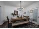 Bright dining room with modern light fixture, table with bench and chairs, and a view to the backyard at 1575 Lewis Farm Rd, Kings Mountain, NC 28086