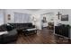 Cozy living room with a comfortable leather sofa, wood floors, and a view into the dining area at 1575 Lewis Farm Rd, Kings Mountain, NC 28086