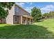 An exterior view of the house and backyard, featuring a wooden patio and green lawn at 176 Pleasant Grove Ln, Mooresville, NC 28115