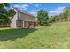 Spacious backyard featuring a wooden patio, green lawn, wood fence, and mature trees at 176 Pleasant Grove Ln, Mooresville, NC 28115