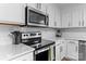 Close-up of kitchen with stainless steel appliances, light countertops, and white subway tile backsplash at 176 Pleasant Grove Ln, Mooresville, NC 28115
