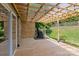 A covered wooden patio with a grill, string lights, and view of the backyard and a wood fence at 176 Pleasant Grove Ln, Mooresville, NC 28115