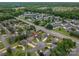 Wide aerial view of the house and neighborhood, highlighting the community pool and lush surrounding trees at 1909 Wexford Ct, Gastonia, NC 28054