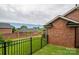 Backyard featuring a lush lawn with black iron fence and brick walls at 1909 Wexford Ct, Gastonia, NC 28054
