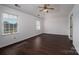 Bright bedroom featuring hardwood floors, ceiling fan, and multiple windows at 1909 Wexford Ct, Gastonia, NC 28054