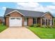 Beautiful brick home boasts a manicured lawn, driveway, and attached two-car garage at 1909 Wexford Ct, Gastonia, NC 28054