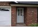 Close up of front door and garage of brick house with manicured lawn at 1909 Wexford Ct, Gastonia, NC 28054