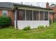 Screened in porch attached to a brick home with green lawn at 1909 Wexford Ct, Gastonia, NC 28054