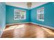 Bright bedroom with hardwood floors, large windows, and vibrant blue walls at 204 Blanche Ave, Belmont, NC 28012