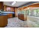 Spacious kitchen featuring wooden cabinetry, island with sink, and large windows to living area at 204 Blanche Ave, Belmont, NC 28012