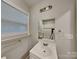 Bright bathroom featuring white vanity, white sink and mirror reflecting the shower at 2214 Grimes St, Charlotte, NC 28206