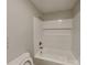 Bathroom featuring a white tile shower-tub combination, complementing the neutral-toned walls and simple fixtures at 2214 Grimes St, Charlotte, NC 28206