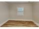 This bedroom features neutral walls, wood-look floors, and a window with blinds at 2214 Grimes St, Charlotte, NC 28206
