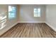 A bedroom featuring wood-look flooring, two windows providing natural light, and fresh, neutral paint throughout at 2214 Grimes St, Charlotte, NC 28206