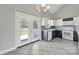 Well-lit kitchen with tile floors, black and white cabinets and doors to the backyard at 2706 Stagbuck Dr, Gastonia, NC 28052