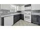 A kitchen features white appliances, two-tone cabinets, decorative backsplash, and tile floors at 2706 Stagbuck Dr, Gastonia, NC 28052