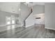 A spacious living room features gray flooring, a staircase, an entryway with shiplap, and vaulted ceilings at 2706 Stagbuck Dr, Gastonia, NC 28052